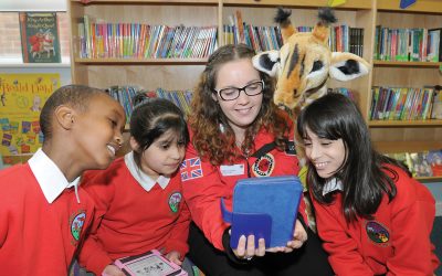 Volunteer reads to children in school for Step Up To Serve