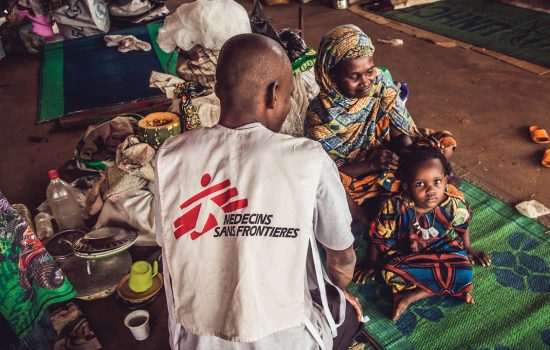 Medecins Sans Frontieres volunteer health worker supports mother and children