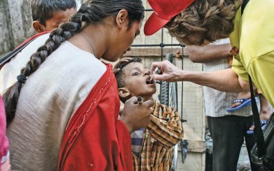 Rotary member delivers polio immunisation to child in India