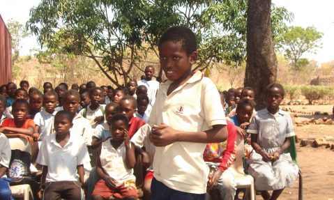 Child recites poetry from a book supplied by the Literacy in a Box charity