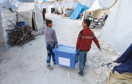 Two boys carry Aquabox in refugee camp