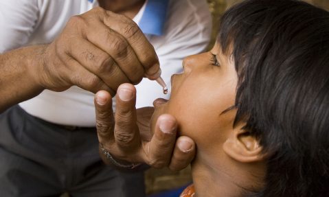 Rotary member administers polio vaccine to child in Nepal our causes fighting disease