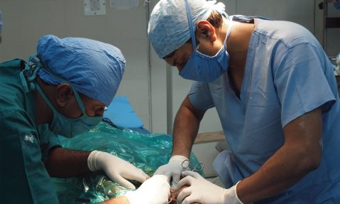 surgeon performs surgery on polio victim