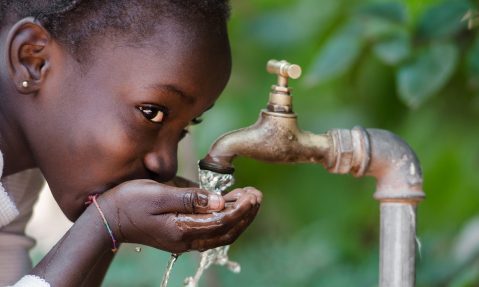 young girl drinks clean water from tap rotary foundation