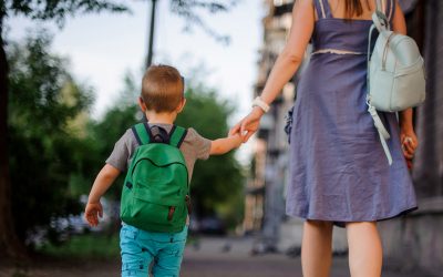 mother and young son walking to school backpack