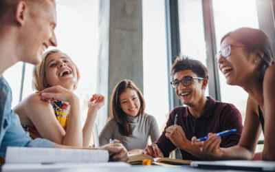 Group of happy young students in library.