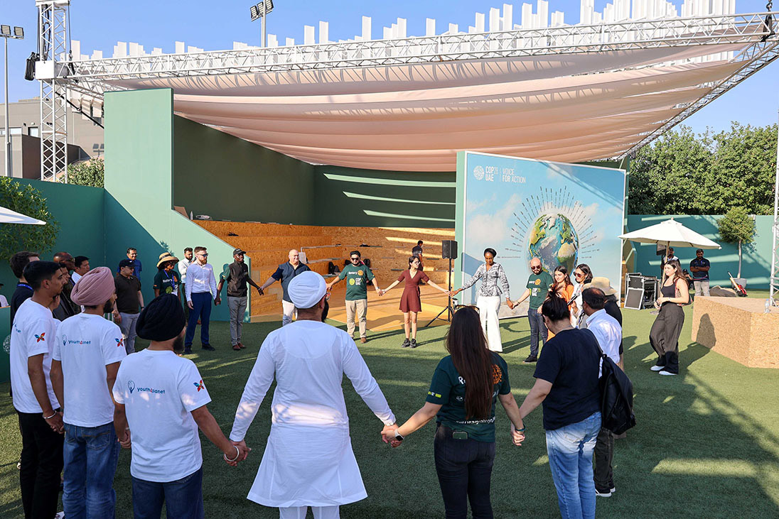 Rotary volunteers holding hands in circle at COP28